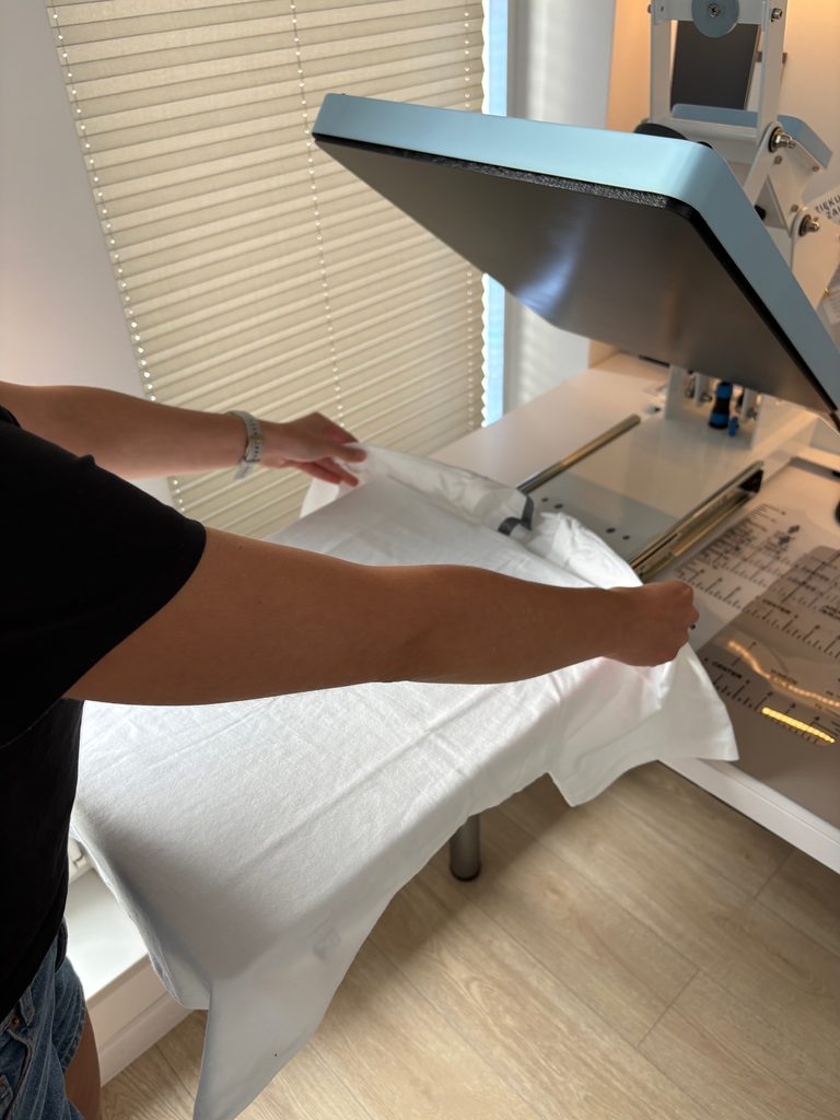 Koszulka oversized fit na prasie podczas przygotowywania do nałożenia nadruku.  